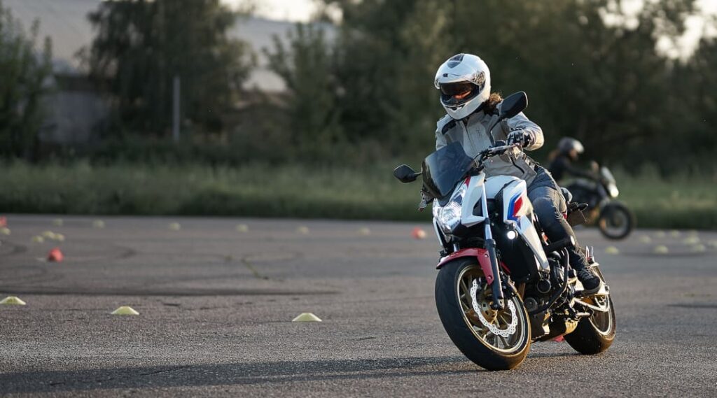 Fahrschüler übt auf dem Motorrad beim Fahrtraining auf dem Übungsplatz